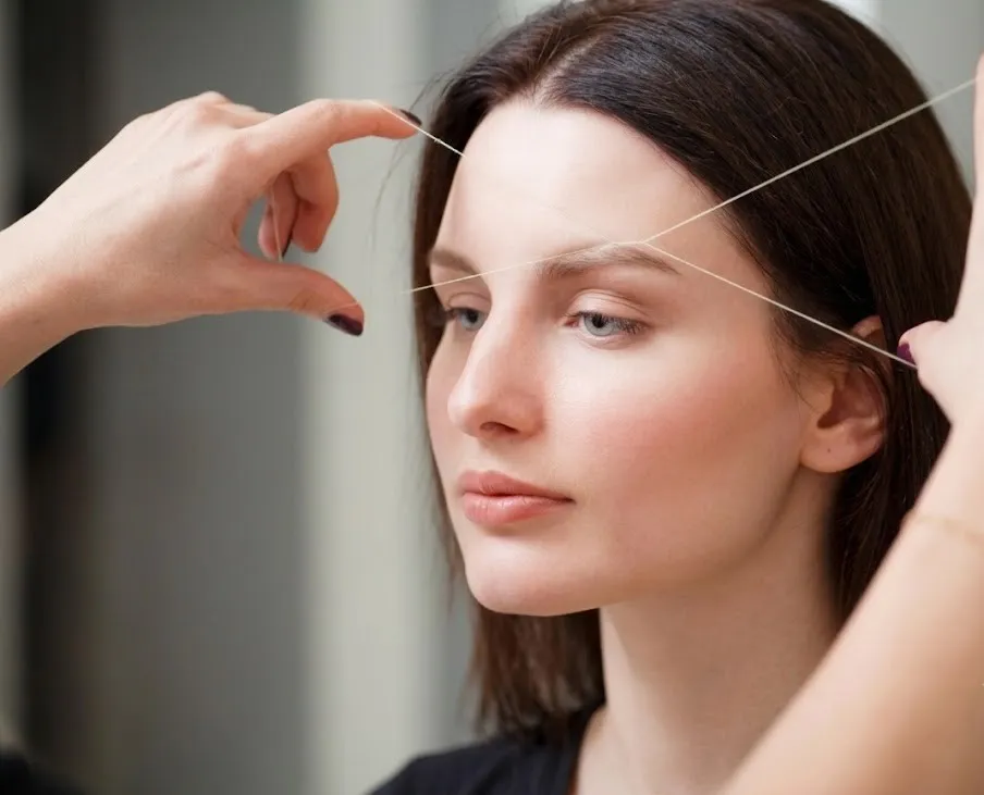 Client receiving professional eyebrow threading at NY Brows in Financial District